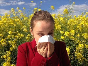 une femme se mouche suite des allergies aux pollens