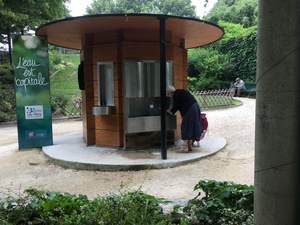 Une femme âgée vient chercher de l'eau potable dans une fontaine de Paris