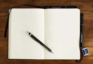un cahier avec des pages blanches et un stylo pour accueillir les mots