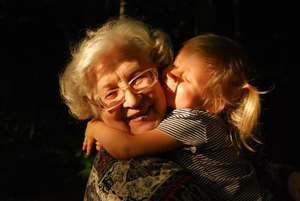 une petite fille embrasse sa grand-mère